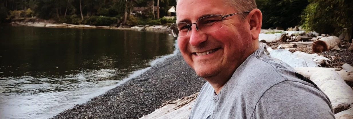 smiling young doctor sits on a beach