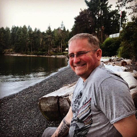 smiling young doctor sits on a beach