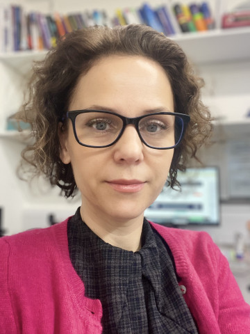 Young female doctor with glasses and pink cardigan