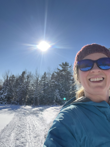 a woman outside with snow in the background